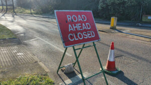 Road Ahead Closed sign with cone