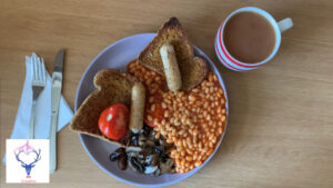 Overhead view of cooked breakfast with mug of tea