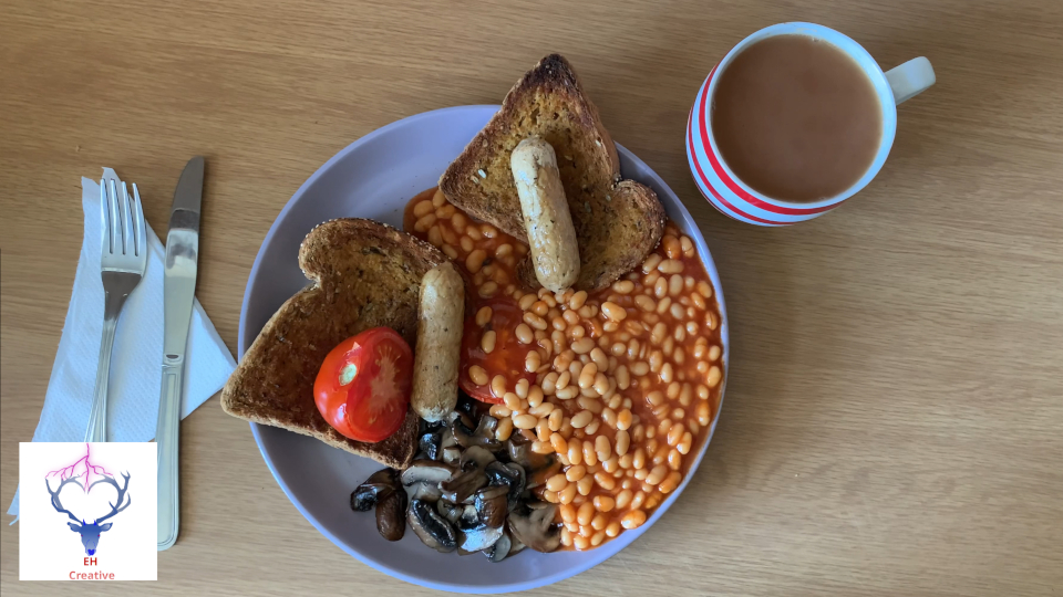 Overhead view of cooked breakfast with mug of tea